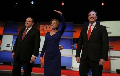 Former Arkansas Governor Mike Huckabee (L), former HP CEO Carly Fiorina and former U.S. Senator Rick Santorum (R) pose together before the start of their debate for lower polling candidates at the Fox Business Network Republican presidential candidates debate in North Charleston, South Carolina January 14, 2016.