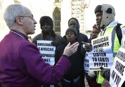 The Archbishop of Canterbury Justin Welby (L) speaks with protestors in the grounds of Canterbury Cathedral in Canterbury, southern Britain January 15, 2016. The Anglican Church has slapped sanctions on its liberal U.S. branch for supporting same-sex marriage, a move that averted a formal schism in the world's third largest Christian denomination but left deep divisions unresolved. The Anglican communion, which counts some 85 million members in 165 countries, has been in crisis since 2003 because of arguments over sexuality and gender between liberal churches in the West and their conservative counterparts, mostly in Africa.