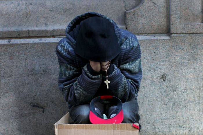 Credit : A homeless man sits along a sidewalk on East 42nd Street in the Manhattan borough of New York City, January 4, 2016. New York Governor Andrew Cuomo signed an executive order on Sunday requiring local officials throughout the state to force the homeless in