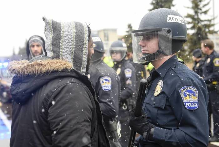 A member of the Black Lives Matter protesters argues with a police officer as they shut down the main road to the Minneapolis St. Paul Airport following a protest at the Mall of America in Bloomington, Minnesota, December 23, 2015. Demonstrations by Black Lives Matter to protest police killings of black men took place in Minnesota and California on Wednesday, a day the activist group dubbed 'Black Xmas' to show it could impact the economy on one of the busiest shopping days of the year.