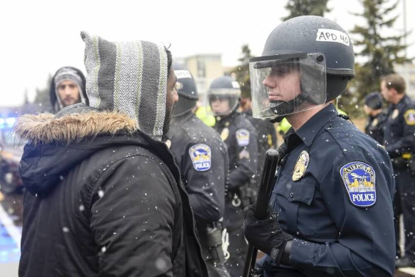 A member of the Black Lives Matter protesters argues with a police officer as they shut down the main road to the Minneapolis St. Paul Airport following a protest at the Mall of America in Bloomington, Minnesota, December 23, 2015. Demonstrations by Black Lives Matter to protest police killings of black men took place in Minnesota and California on Wednesday, a day the activist group dubbed "Black Xmas" to show it could impact the economy on one of the busiest shopping days of the year.