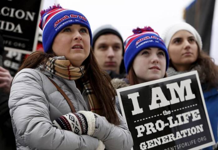 (L-R) Pro-life supporters Marian Rumley, Taylor Miller and Sophie Caticchio from Minnesota listen to speeches at the National March for Life rally in Washington January 22, 2016. The rally marks the 43rd anniversary of the U.S. Supreme Court's 1973 abortion ruling in Roe v. Wade.