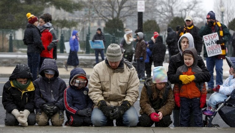 The pro-life DiIulio family from Fairfield, Pennsylvania prays in front of the U.S. Supreme Court (not pictured) during the National March for Life rally in Washington January 22, 2016. The rally marks the 43rd anniversary of the U.S. Supreme Court's 1973 abortion ruling in Roe v. Wade.
