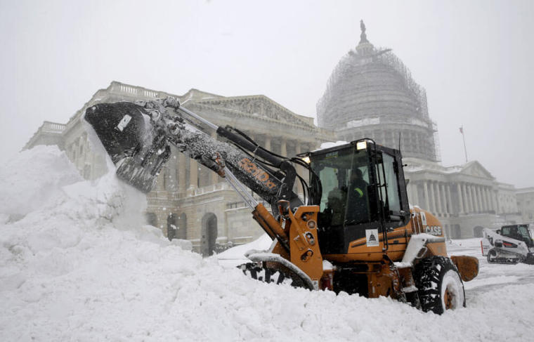 A Capitol Hill employee uses a heavy earth moving machine to clear snow during a winter storm in Washington January 23, 2016. A winter storm dumped nearly 2 feet (58 cm) of snow on the suburbs of Washington, D.C., on Saturday before moving on to Philadelphia and New York, paralyzing road, rail and airline travel along the U.S. East Coast.