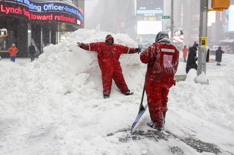 Members of the Times Square Alliance snow clearing team take a photo on a snowbank at Times Square in the Manhattan borough of New York January 23, 2016. A winter storm dumped nearly 2 feet (58 cm) of snow on the suburbs of Washington, D.C., on Saturday before moving on to Philadelphia and New York, paralyzing road, rail and airline travel along the U.S. East Coast.