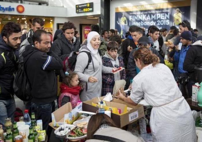 Volunteers distribute food and drinks to migrants who arrived at Malmo train station in Sweden on the morning of September 10, 2015.
