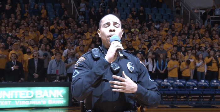 Police officer Carlton Smith performs the Star Spangled Banner at a college basketball game in Morgantown, West Virginia.