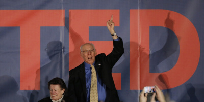 U.S. Republican presidential candidate Ted Cruz's father Rafael Cruz raises his arm in victory, as his mother Eleanor Darragh looks on, at his Iowa caucus night rally in Des Moines, Iowa, February 1, 2016.