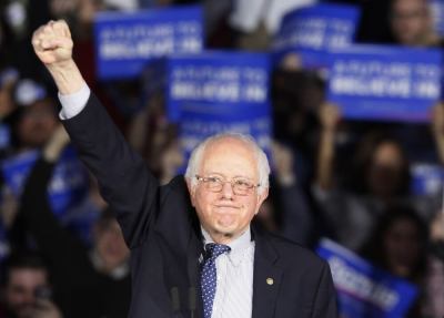 U.S. Democratic presidential candidate Bernie Sanders raises a fist as he speaks at his caucus night rally Des Moines, Iowa February 1, 2016,