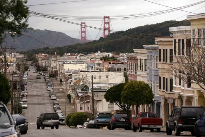 The Golden Gate Bridge is seen in the background above a neighborhood of tightly-packed homes in the Richmond District in San Francisco, California, March 27, 2012.