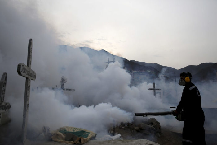 A health worker carries out fumigation as part of preventive measures against the Zika virus and other mosquito-borne diseases at the cemetery of Carabayllo on the outskirts of Lima, Peru, February 1, 2016.