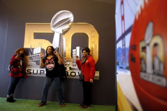Fans pose in front of a poster before NFL Super Bowl 50 in San Francisco, California, United States, February 4, 2016.