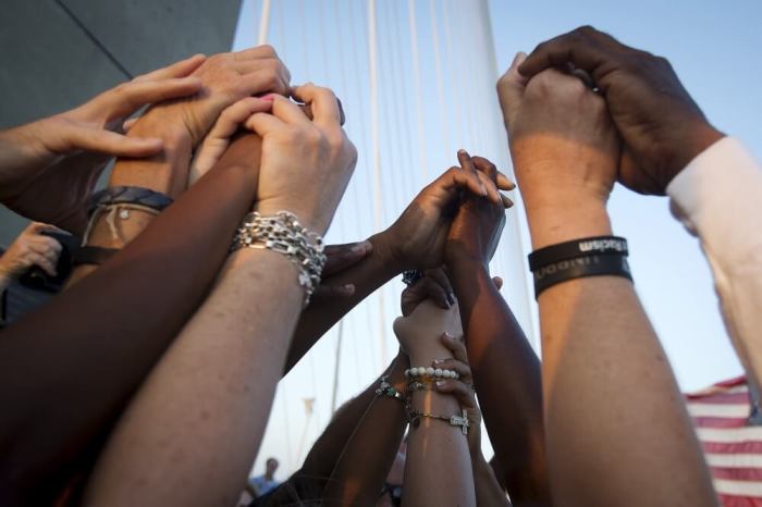 People of different races hold hands as they gather on the Arthur Ravenel Jr. bridge in Charleston, June 21, 2015, after the first service at the Emanuel African Methodist Episcopal Church since a mass shooting left nine people dead.