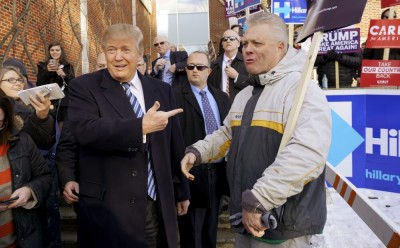 U.S. Republican presidential candidate Donald Trump points at a supporter at a polling place for the presidential primary in Manchester, New Hampshire, February 9, 2016.
