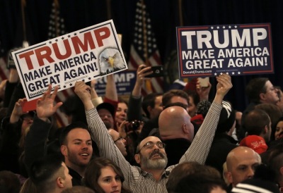 Supporters celebrate as they hold placards at Republican U.S. presidential candidate Donald Trump's 2016 New Hampshire presidential primary election night rally in Manchester, New Hampshire, February 9, 2016. 2016.