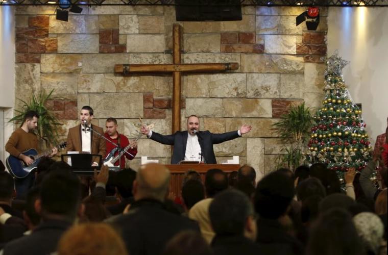 Christians pray during a mass on Christmas at a church in Baghdad, Iraqi, December 25, 2015.