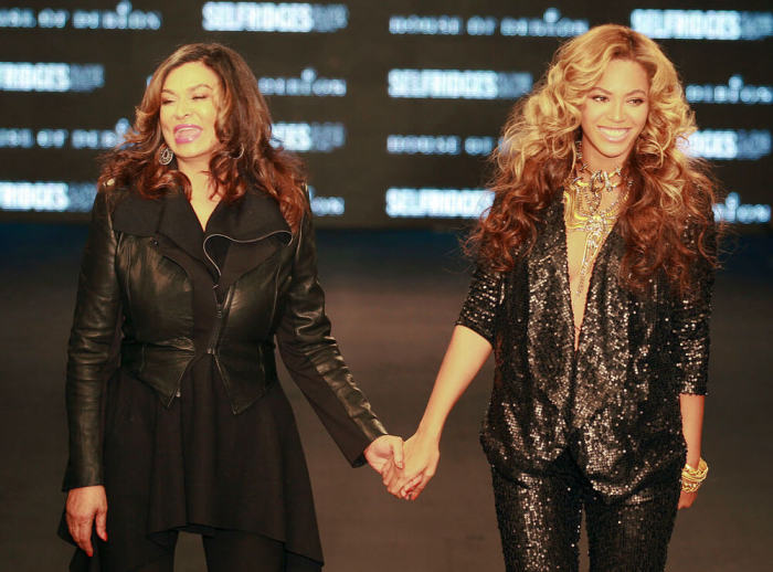 U.S. singer Beyonce Knowles (R) holds hands with her mother Tina Knowles on the catwalk after the launch of their first collection, The House of Dereon, at Selfridges September 17, 2011.