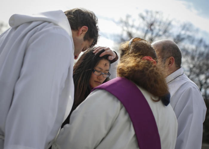 A woman receives ashes in observance of Ash Wednesday from clergy of the Gustavus Adolphus Lutheran Church at Union Square in New York, March 5, 2014. Christians celebrated Ash Wednesday, which serves as a reminder that 'as a man is dust, so unto dust he shall return' and marked the beginning of a 40-day period of Lent in the Roman Catholic calendar.