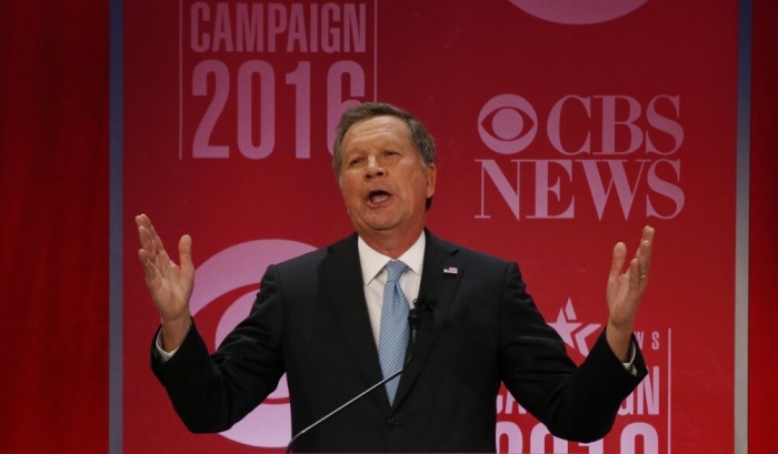 Republican U.S. presidential candidate Governor John Kasich reacts to the attacks flying between his rivals for the Republican presidential nomination at the Republican U.S. presidential candidates debate sponsored by CBS News and the Republican National Committee in Greenville, South Carolina February 13, 2016.