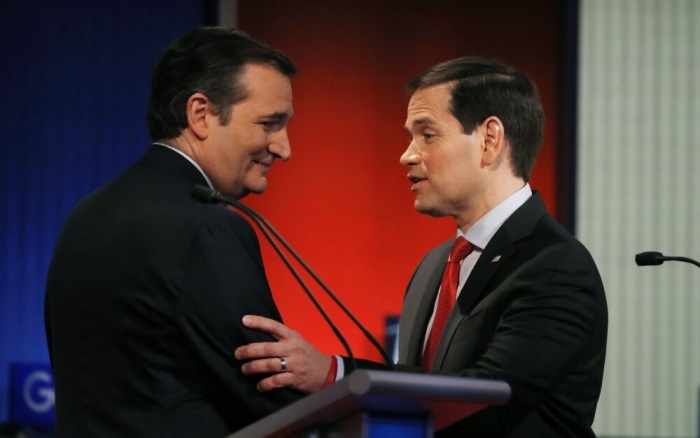 Republican U.S. presidential candidates and U.S. Senators Ted Cruz (L) and Marco Rubio shake hands and talk at the end of the debate held by Fox News for the top 2016 U.S. Republican presidential candidates in Des Moines, Iowa January 28, 2015.