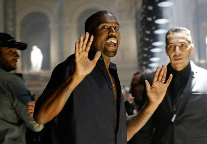 Rapper Kanye West reacts as he arrives to attend the Israeli-American designer Alber Elbaz Spring/Summer 2015 women's ready-to-wear collection for fashion house Lanvin during Paris Fashion Week September 25, 2014.