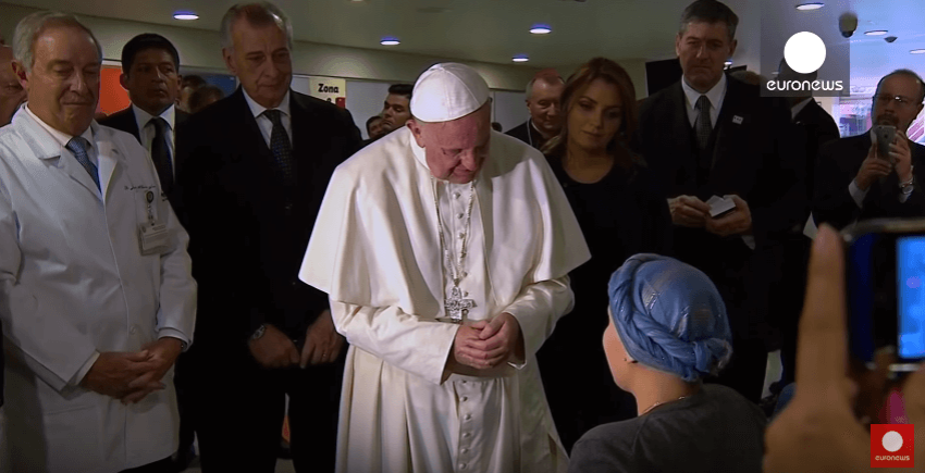 Pope Francis listens with others to a girl sing "Ave Maria" at a hospital in Mexico.
