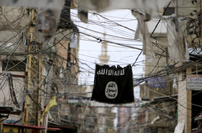 An Islamic State flag hangs amid electric wires over a street in Ain al-Hilweh Palestinian refugee camp, near the port-city of Sidon, southern Lebanon, January 19, 2016.