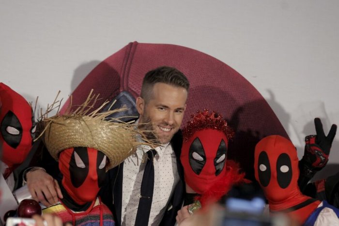 Actor Ryan Reynolds poses with fans as he arrives for the premiere of 'Deadpool' in New York, February 8, 2016.