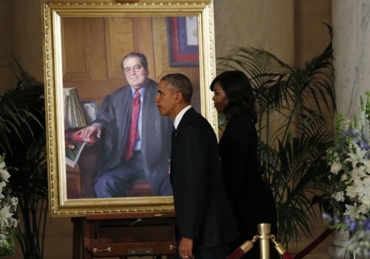 U.S. President Barack Obama and first lady Michelle Obama walk past a portrait of U.S. Supreme Court Justice Antonin Scalia after paying their respects at his casket in the U.S Supreme Court's Great Hall in Washington February 19, 2016. Scalia died on February 13, 2016 at the age of 79.