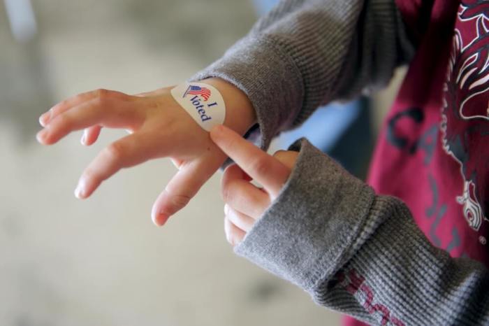 A boy shows an 'I voted' sticker on his hand after his father voted at the Irmo Fire District station in Columbia, South Carolina February 20, 2016. South Carolina voters are going to the polls today to vote in the Republican presidential primary.
