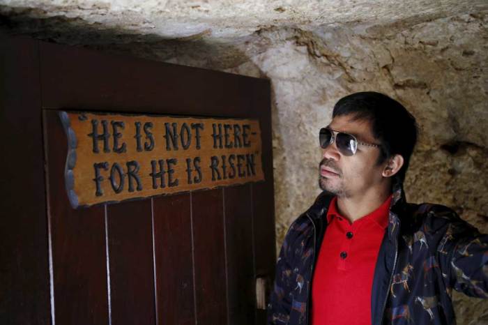 Filipino boxer Manny Pacquiao stands next to a sign during a visit to The Garden Tomb site outside Jerusalem's old city November 21, 2015.