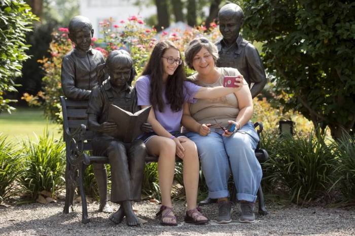 Amy Burchfield and her daughter Scout Burchfield take a photo with the 'A Celebration of Reading' sculpture at the Old Monroe County Courthouse, the setting of 'To Kill a Mockingbird' in Monroeville, Alabama July 14, 2015. The southern hometown of author Harper Lee, is celebrating the release of 'Go Set a Watchman', Lee's first published novel in 55 years.