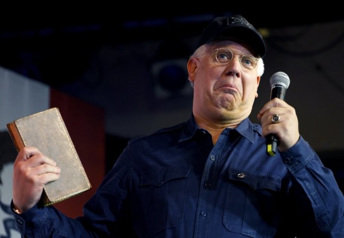 Radio personality Glenn Beck, holds George Washington's copy of 'Don Quixote' as he introduces U.S. Republican presidential candidate Ted Cruz at a campaign event at Adventure Christian Community in Davenport, Iowa January 31, 2016.