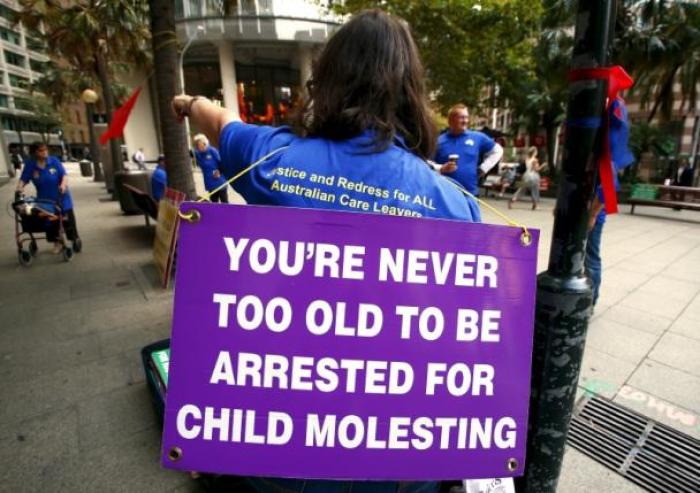 Victims and relatives of children who claim they were sexually abused by the Catholic Church hold placards as they stand outside the venue for Australia's Royal Commission into Institutional Response to Child Sexual Abuse in Sydney, Australia, February 29, 2016.