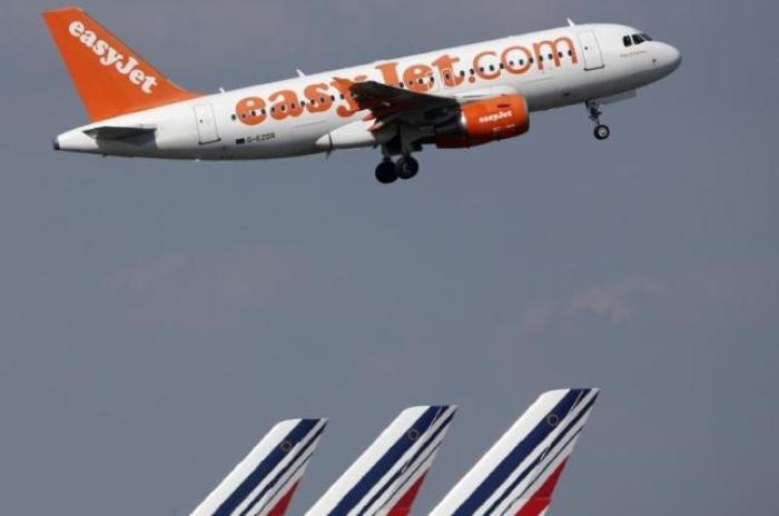 An easyJet aircraft takes-off past Air France plane tails at the Charles-de-Gaulle airport, near Paris, September 16, 2014.
