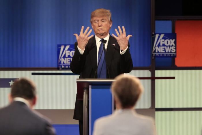 Republican U.S. presidential candidate Donald Trump shows off the size of his hands as Fox News Channel moderators Brett Baier (L) and Megyn Kelly (R) look on at the U.S. Republican presidential candidates debate in Detroit, Michigan, March 3, 2016.