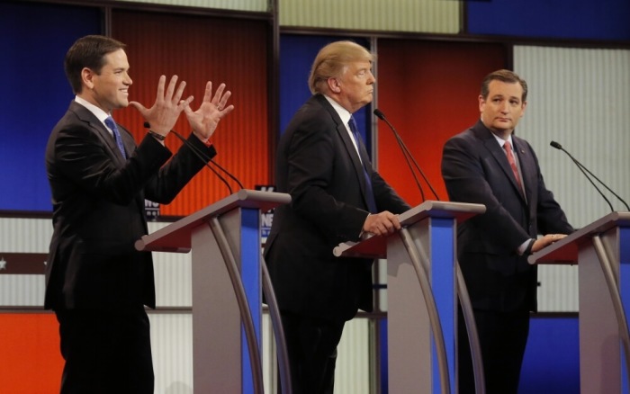 Republican U.S. presidential candidate Marco Rubio (L) shows off the size of his hands after rival candidate Donald Trump did so first as Ted Cruz (R) looks on at the start of the U.S. Republican presidential candidates debate in Detroit, Michigan, March 3, 2016.