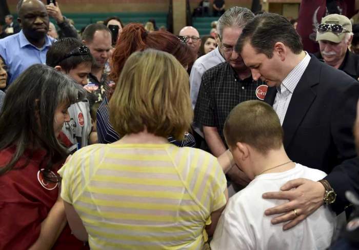 U.S. Republican presidential candidate Ted Cruz (R) prays with a family after speaking at a campaign rally in Las Vegas, Nevada February 22, 2016.