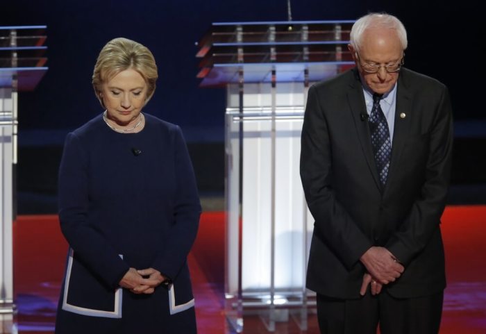 Democratic U.S. presidential candidates Hillary Clinton and U.S. Senator Bernie Sanders observe a moment of silence for the late U.S. first lady Nancy Reagan before the start of the Democratic U.S. presidential candidates' debate in Flint, Michigan, March 6, 2016.