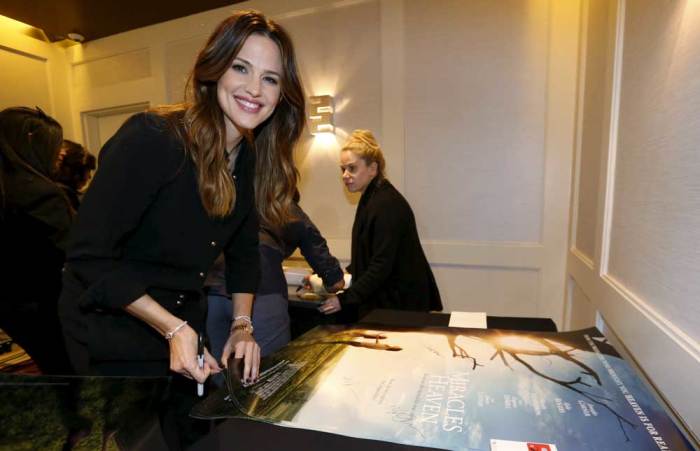 Cast member Jennifer Garner autographs posters at a photo call for the movie 'Miracles from Heaven' in West Hollywood, California March 4, 2016.