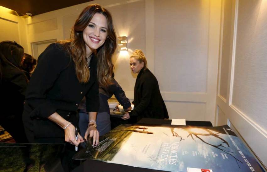 Cast member Jennifer Garner autographs posters at a photo call for the movie "Miracles from Heaven" in West Hollywood, California March 4, 2016.