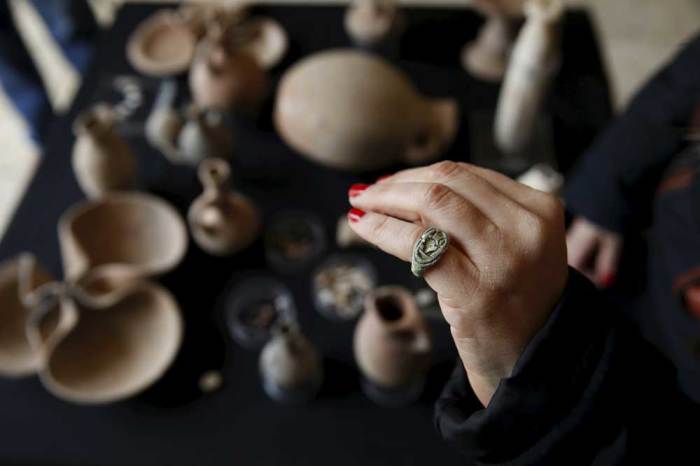 Yoli Shwartz, spokesperson for the Israel Antiquities Authority (IAA), wears an ancient seal ring typical of Egyptian culture, discovered during an archaeological excavation in a cave in southern Israel, at the Rockefeller Archaeological Museum in Jerusalem April 1, 2015. A statement from the IAA said artifacts found in the cave attest to the existence of an Egyptian administrative center in the region 3,400 years ago.