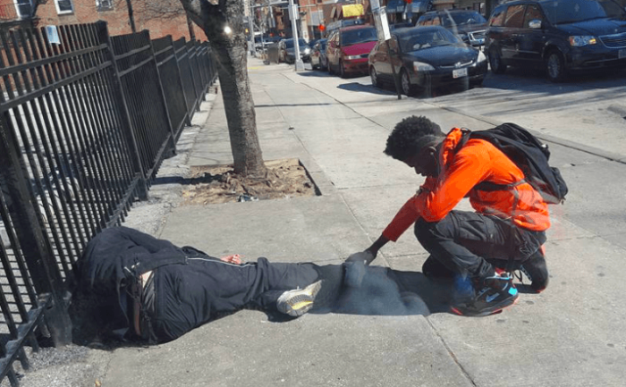 A Baltimore teen shares a prayer with a homeless person near a bus stop.