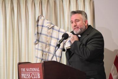 Chaldean priest Douglas al-Bazi holds up the blood-stained shirt he was wearing when he was abducted and tortured for nine days by Islamic terrorists in 2006 during a press conference hosted by In Defense of Christians and the Knights of Columbus in Washington D.C. on March 10, 2016.