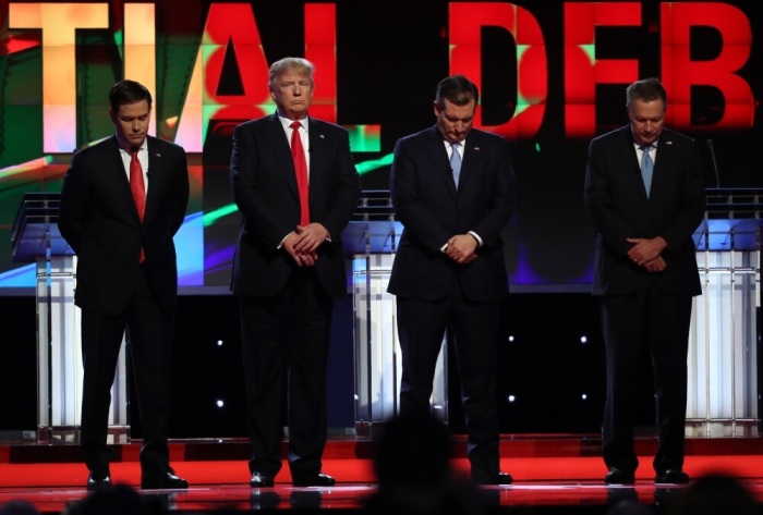 Republican U.S. presidential candidate Donald Trump (2nd from L) looks up as rival candidates Marco Rubio (L), Ted Cruz and John Kasich (R) bow their heads for a moment of silence for former first lady Nancy Reagan at the start of the Republican U.S. presidential candidates debate sponsored by CNN at the University of Miami in Miami, Florida March 10, 2016.