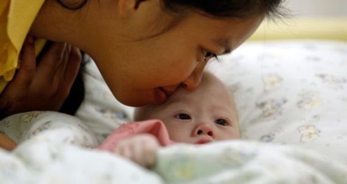 Gammy, a baby born with Down syndrome, is kissed by his surrogate mother Pattaramon Janbua at a hospital in Chonburi province in China in this undated photo.
