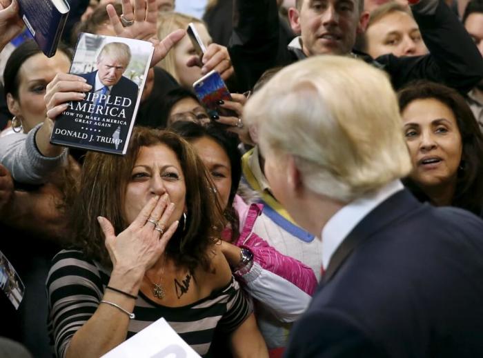 A woman blows a kiss to Republican presidential candidate Donald Trump (R) after Trump autographed her chest at his campaign rally in Manassas, Virginia, December 2, 2015.