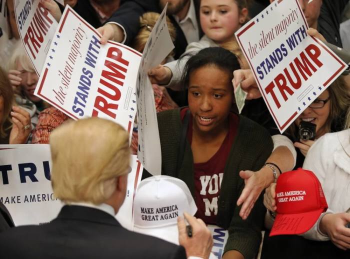 A supporter talks to Republican presidential candidate Donald Trump as he signs autographs following a campaign event in Concord, North Carolina, March 7, 2016.