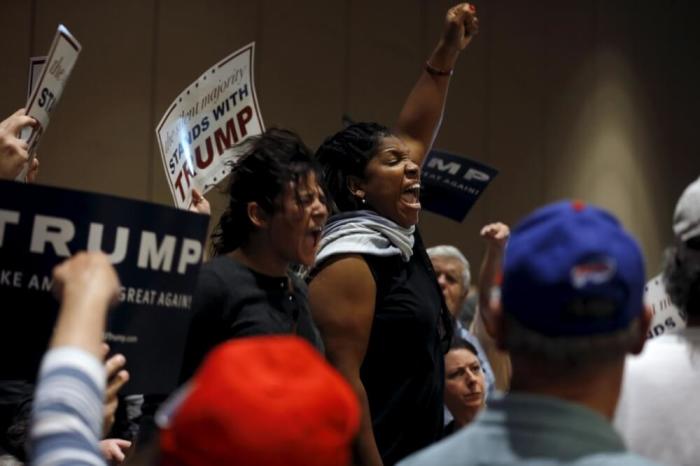 Protesters shout as they are escorted out of the building during U.S. Republican presidential candidate Donald Trump's campaign rally at the Tampa Convention Center in Tampa, Florida, March 14, 2016.