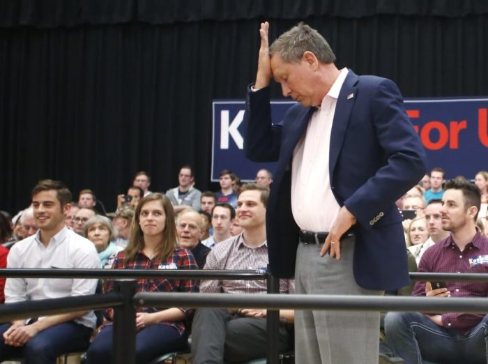 U.S. Republican presidential candidate John Kasich puts his hand to his head at a campaign town hall event in Orem, Utah March 18, 2016.